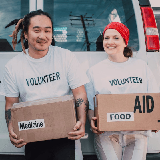 Volunteers distributing medicine and food to people in need