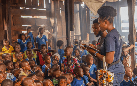 Man and woman counting children during a community event